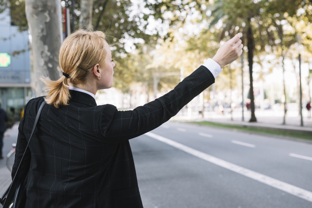 Rear View Young Woman Hailing Rideshare Taxi Car Road 23 2147972865, Entrust Insurance St. Clair Shores, MI and Southeast Michigan