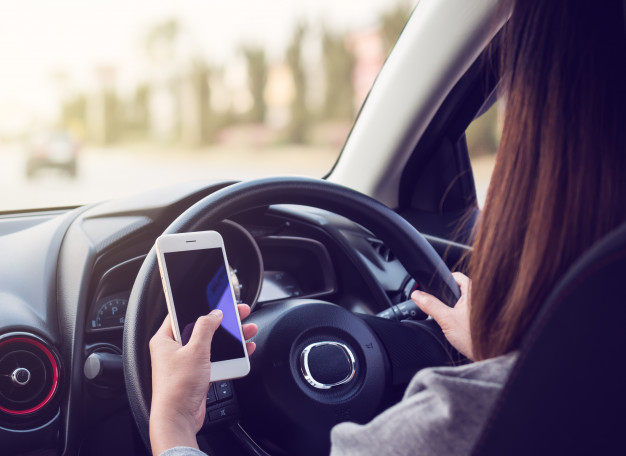 Woman Driving Using Smartphone Road 77206 31, Entrust Insurance St. Clair Shores, MI and Southeast Michigan